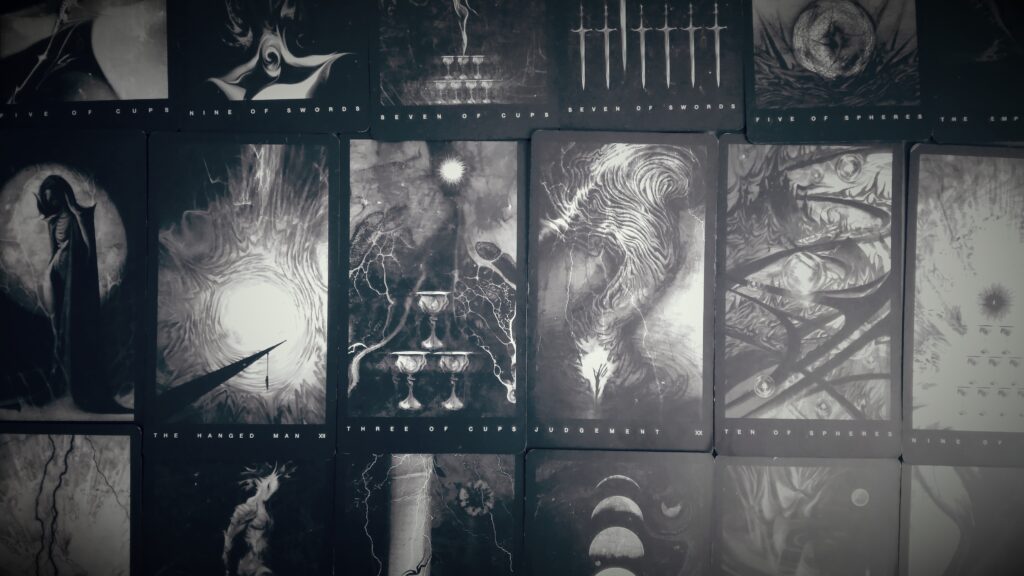 overlapping tarot cards spread out on a tabletop