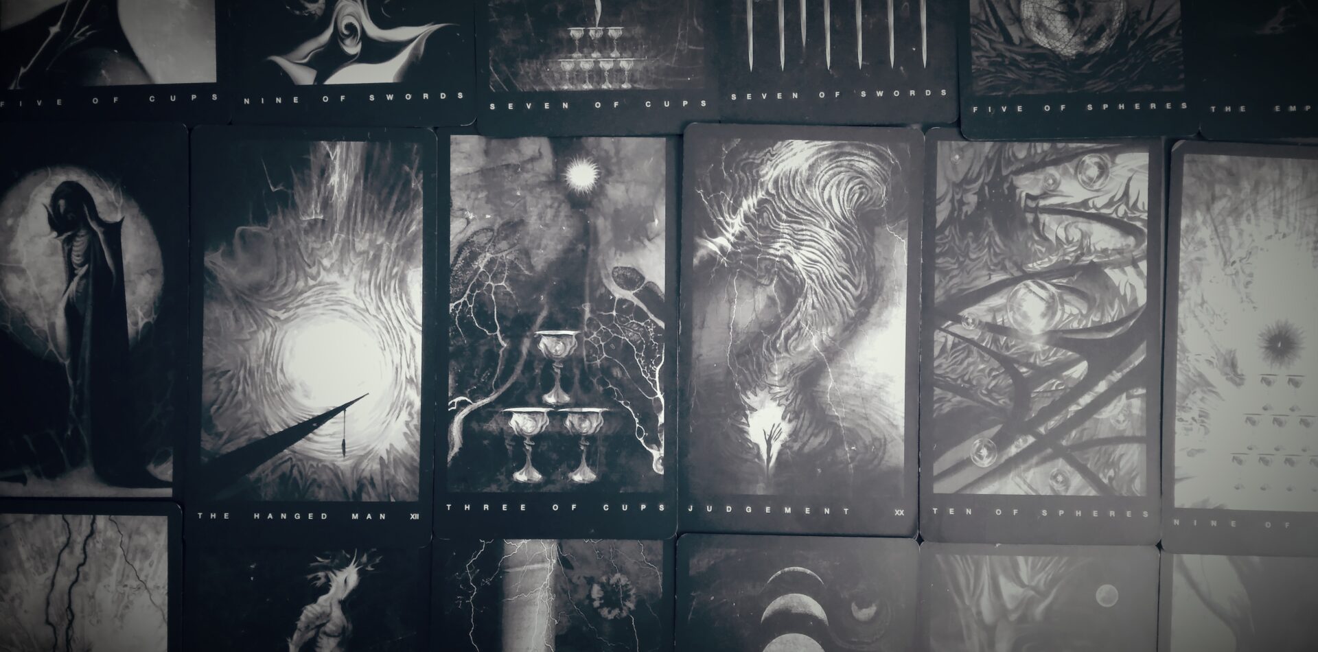 overlapping tarot cards spread out on a tabletop