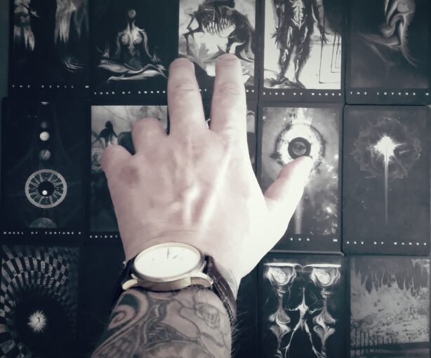 Hands holding a tarot deck in a luxurious velvet setting