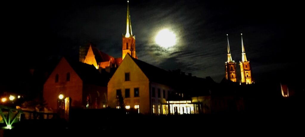 A person doing a tarot reading under the full moon outdoors in Wroclaw, Poland