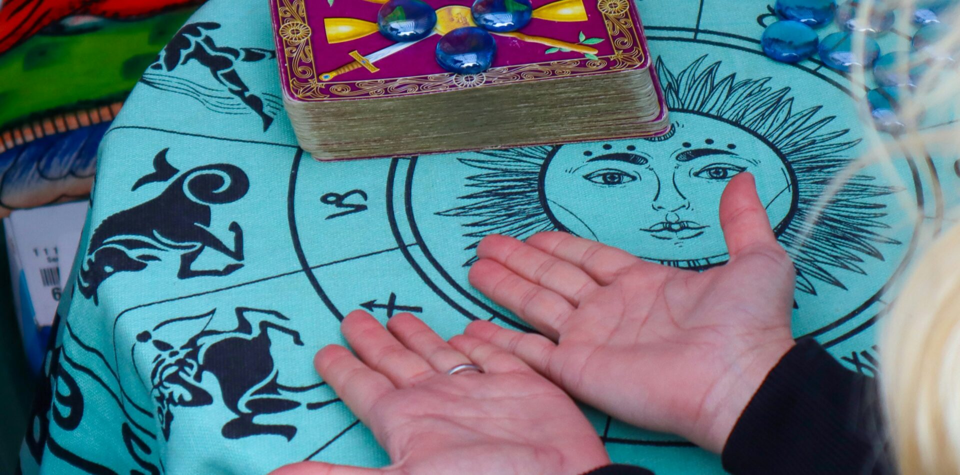 Hands hovering over a tarot deck and illuminated palms, cinematic lighting