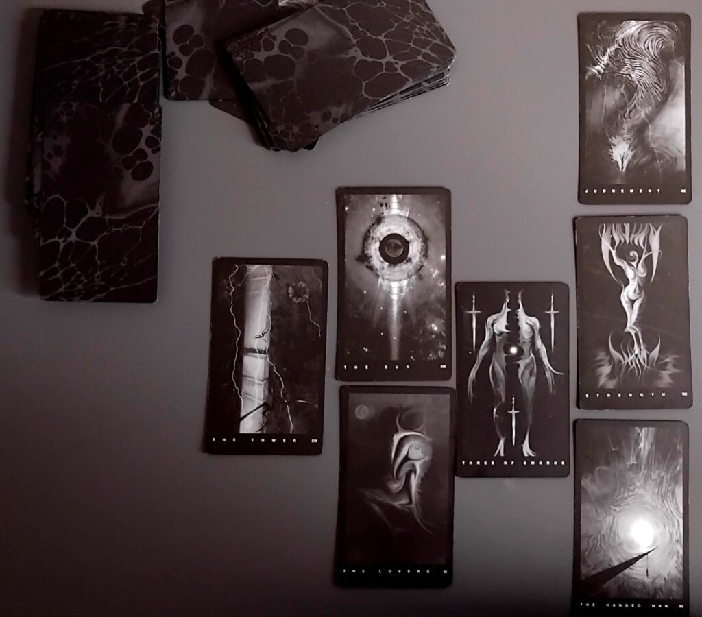 Shadow tarot card spread laid out on a dark surface, illustrating archetypes and symbolic exploration.